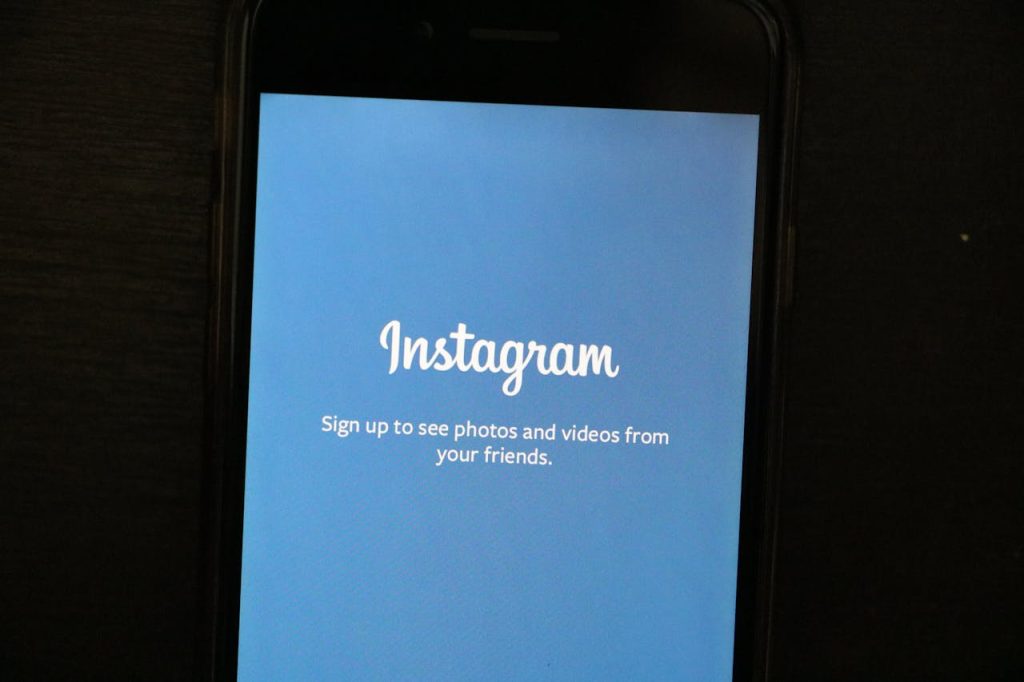 Close-up of a smartphone displaying the Instagram app welcome screen, inviting users to sign up.